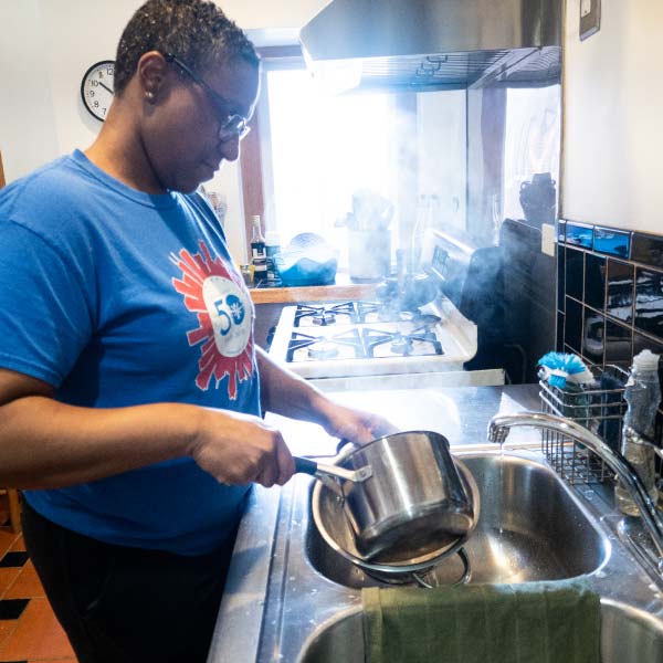 A person washing dishes in a shared kitchen