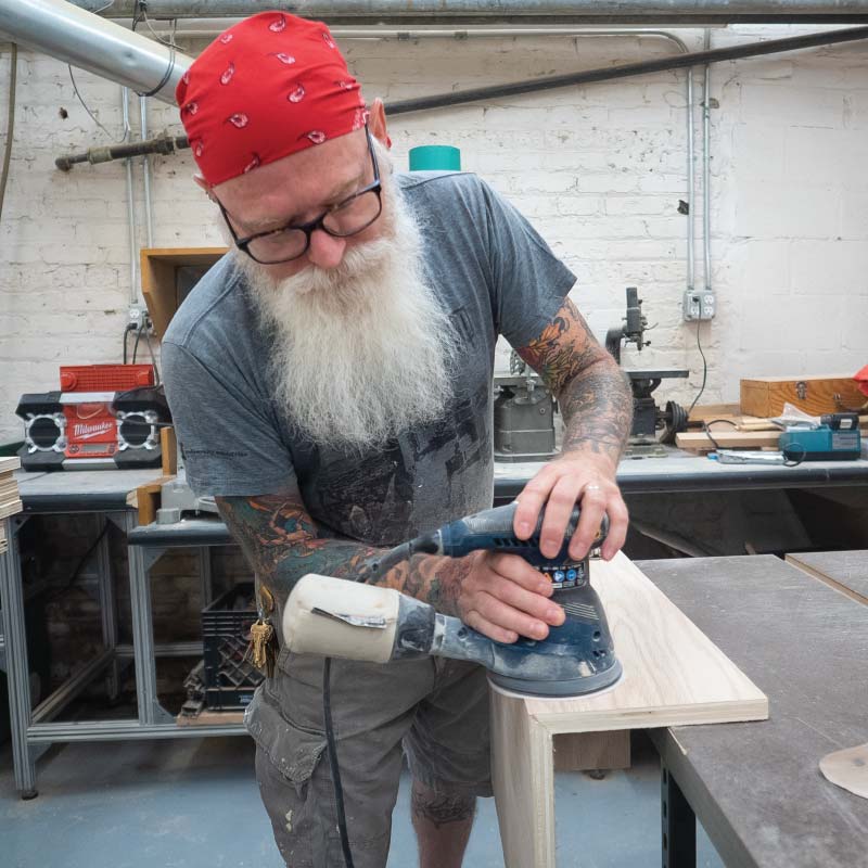 A person sanding in a wood shop